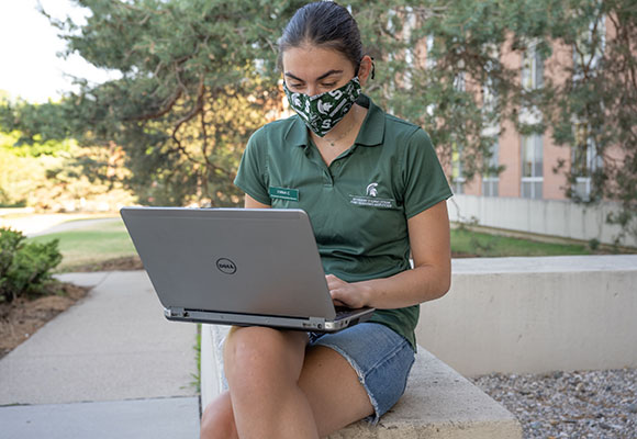 Student outside on computer