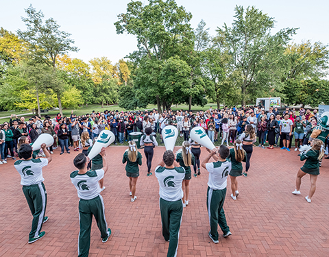 large group of students at a rally with cheerleaders